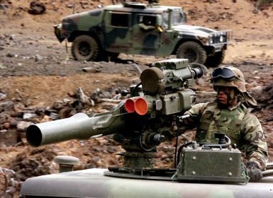 A US Marine from 2nd Battalion, 3rd Marines, atop a High-Mobility Multipurpose Wheeled Vehicle (HMMWV), readies a TOW missile launcher for a Combined Arms Live Fire Exercise at Pohakuloa Training Area on the Big Island of Hawaii. Another HMMWV is visible in the background