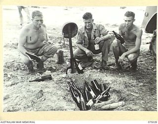 MILILAT, NEW GUINEA. 1944-08-03. MEMBERS OF THE 10TH UNITED STATES AIR LIAISON COMPANY REVERENTLY LAYING THEIR "DEAD MARINES" TO REST THE MORNING AFTER RECEIVING THEIR BEER ISSUE. THEY ARE:- ..