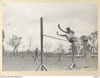 WONDECLA AREA, QLD. 1945-01-19. LANCE CORPORAL A D TAYLOR, 2/9 CAVALRY (COMMANDO) REGIMENT CLEARING THE BAR AT 5 FEET 3 INCHES WHILE REPRESENTING DIVISION A GROUP TROOPS IN THIS EVENT DURING THE 9 ..