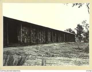 BOGADJIM, NEW GUINEA. 1944-04-26. FOOD STACKED IN ONE OF THE STORE SHEDS OF NO. 5 BASE SUPPLY DEPOT. THE FOOD IS STACKED TO ASSIST AIR FLOW AROUND THE CONTENTS FOR PRESERVATION IN TROPICAL AREAS