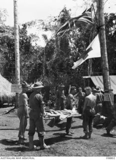 DUMPU, NEW GUINEA. 1943-10-15. A WOUNDED SOLDIER FROM THE FORWARD AREA BEING CARRIED ON A STRETCHER INTO THE MAIN DRESSING STATION OF THE 2/6TH AUSTRALIAN FIELD AMBULANCE . SHOWN ARE:- VX20846 ..