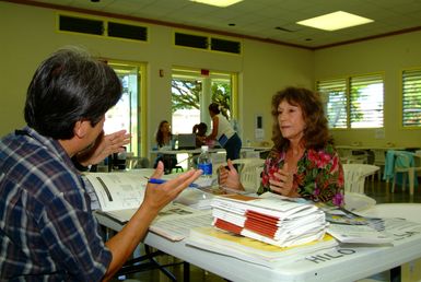 [Earthquake] Hilo, HI, November 11, 2006 - FEMA Local resident Vicki O'Bryant discusses the registration procedure with FEMA Mitigation Specialist George Garcia at the Hilo Disaster Recovery Center (DRC). The DRC opened and the disaster victims were able to begin registering in person for Individual Assistance (IA). Adam DuBrowa/FEMA.