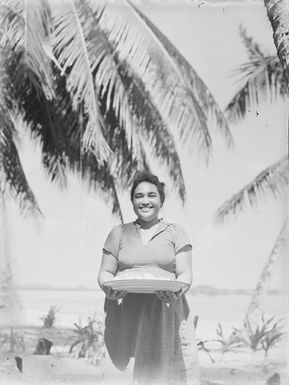 [Half-length portrait of a Polynesian woman holding a food platter]