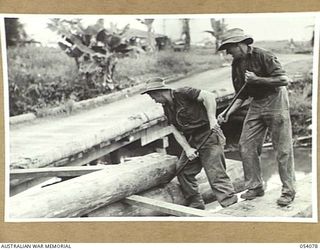 MILNE BAY, NEW GUINEA, 1943-07-12. TROOPS OF THE 21ST AUSTRALIAN ARMY FIELD COMPANY, ROYAL AUSTRALIAN ENGINEERS, BUILDING A NEW BRIDGE ACROSS LAUIAM CREEK. VX120885 SAPPER J.A. BARRATT (LEFT) AND ..