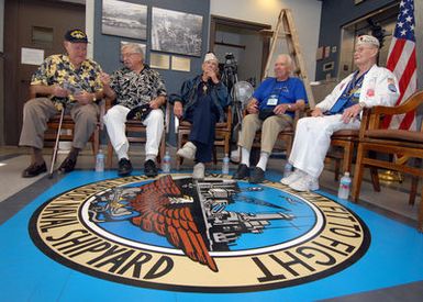 U.S. Navy USS OKLAHOMA survivors (left to right), Ray Turpin, Jerry Tessaro, Paul Goodyear, George Smith and Raymond Richmond sit at the crest of the Pearl Harbor Naval Shipyard logo, which reads the motto,"We make them fit to fight,"during the USS OKLAHOMA Lobby Display Dedication ceremony at Naval Station Pearl Harbor, Hawaii. The motto was adopted after the events of on Dec. 7, 1941, and the shipyard's restoration of the crippled Pearl Harbor fleet. The renovation and dedication also honored the historic tie between the Pearl Harbor Shipyard workers who aided in the rescue of 32 Sailors from the capsized ship in the days following Dec. 7, 1941. (U.S. Navy PHOTO by Mass Communication...