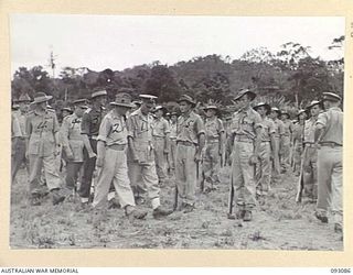 LAE AREA, NEW GUINEA, 1945-06-16. LT-GEN V.A.H. STURDEE, GOC FIRST ARMY (1) AND MAJ C. CRUICKSHANK, COMMANDING OFFICER 24 MECHANICAL EQUIPMENT PARK COMPANY (2), INSPECTING TROOPS OF THE UNIT DURING ..