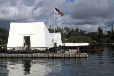 A view of the USS ARIZONA Memorial which spans the sunken hulk of the battleship USS ARIZONA (BB 39). The battleship was sunk in the opening minutes of World War II during the Japanese attack on the harbor. Over 1000 men are entombed in the vessel's hull, which is now a national cemetery