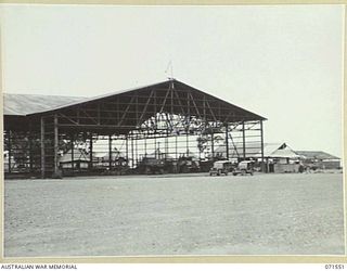 LAE, NEW GUINEA. 1944-03-23. THE HANGAR ALONGSIDE THE LAE AIRSTRIP WITHIN HEADQUARTERS, LAE BASE SUB-AREA, RE-BUILT AND IN OPERATION FOLLOWING BOMB DAMAGE RECEIVED FROM THE ROYAL AUSTRALIAN AIR ..