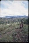 Western Highlands: woman and child, cloud-wreathed mountain range seen across a broad valley