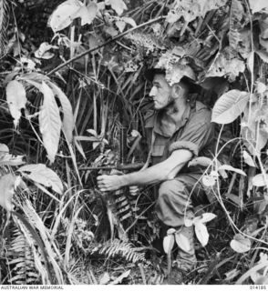 1943-01-22. PAPUA. SANANANDA. AN AUSTRALIAN WITH AN OWEN GUN IN THE DENSE JUNGLE IN THE SANANANDA AREA