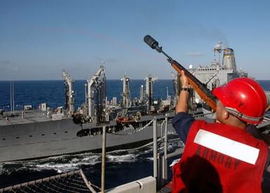 U.S. Navy GUNNER's Mate Third Class Juan Gonzales uses a 7.62 mm M14 rifle to fire a line from the deck of his ship, the Military Sealift Command Henry J. Kaiser Class Oiler USNS KANAWHA (T-AO 196), to the Tarawa Class Amphibious Assault Ship USS SAIPAN (LHA 2) during underway replenishment operations between the two ships in the Mediterranean Sea on Sept. 1, 2006. SAIPAN is currently underway conducting maritime security operations. (Navy photo By Mass Communication SPECIALIST Third Class Gary L. Johnson III) (Released)