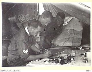 WEWAK POINT, NEW GUINEA. 1945-08-29. INTELLIGENCE SECTION, 19 INFANTRY BRIGADE AT WORK PLOTTING AND MARKING ON MAP THE BRIGADE OPERATIONS IN THE WEWAK SECTOR. IDENTIFIED PERSONNEL ARE:- CORPORAL M. ..