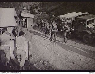 ROUNA, NEW GUINEA. 1943-09-24. TROOPS OF THE 2/12TH BATTALION PASSING VEHICLES HELD UP AT THE ROUNA TRAFFIC CONTROL POST NO. 2 BECAUSE OF BLASTING FURTHER ALONG THE ROAD