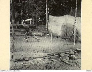 ZENAG, NEW GUINEA, 1944-02-28. VX69607 SAPPER G. REDMAN (1), WHO FORMERLY PLAYED FOR COLAC, VICTORIA, MAINTAINING FORM AT THE CAMP SITE IN TIMNE WATERS OF NO.4 PLATOON, 2/1ST MECHANICAL EQUIPMENT ..