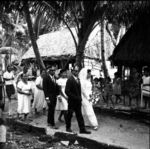 Bride and groom parade the village path followed by attendants and well-wishers