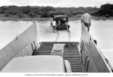 Team members pushing their jeep on Enjebi Island's beach, summer 1964