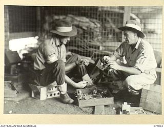 LAE BASE AREA, NEW GUINEA. 1944-12-27. WX34271 CORPORAL N. R. HENDERSON (1) AND W52847 PRIVATE W. J. BRINDLEY (2) OF THE 3RD CORPS SALVAGE UNIT REMOVING SERVICEABLE PARTS FROM RADIO SETS