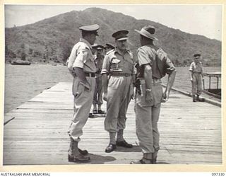 RABAUL, NEW BRITAIN. 1945-09-27. STAFF OFFICERS OF 11 DIVISION CONFER ON TOBOI WHARF WITH LIEUTENANT GENERAL J. NORTHCOTT, CHIEF OF GENERAL STAFF (2) SOON AFTER HIS ARRIVAL AT HEADQUARTERS 11 ..