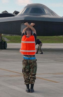 US Air Force (USAF) SENIOR AIRMAN (SRA) Chad Alexander (back to camera), Crew CHIEF, 509th Aircraft Maintenance Squadron (AMXS), marshals a USAF 325th Bomb Squadron (BS), 509th Bomb Wing (BW), B-2 Spirit multi-role stealth bomber, from Whiteman Air Force Base (AFB), Missouri (MO), into its parking spot at Andersen AFB, Guam (GU), as he participates in Exercise CORONET BUGLE 49, which is part of an Air Combat Command (ACC) Global Power mission