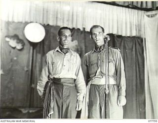 LAE BASE AREA, NEW GUINEA. 1944-12-27. N247743 SERGEANT LES JARRETT (1) AND NX173630 CORPORAL "SANDY" GRAHAM (2) RENDERING A DUET DURING THE CHRISTMAS CONCERT STAGED IN THE AUDITORIUM OF THE 22ND ..