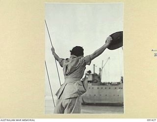 LAE, NEW GUINEA, 1945-05-07. LIEUTENANT-COLONEL M.J. SPENCER, ASSISTANT CONTROLLER AWAS, WAVING FROM A LAUNCH WHILE ON THE WAY TO THE MV DUNTROON, BEFORE DISEMBARKATION OF 342 AWAS FROM AUSTRALIA ..