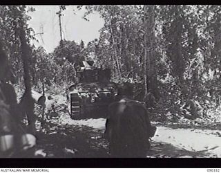 BOUGAINVILLE, 1945-04-05. A MATILDA TANK, COVERED BY INFANTRY OF 61ST INFANTRY BATTALION, WAITING TO MOVE THROUGH TO 25TH INFANTRY BATTALION HQ FROM B ECHELON, WITH AMMUNITION SUPPLIES