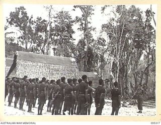 CAPE CUNNINGHAM, NEW BRITAIN, 1945-08-15. MEMBERS OF THE ROYAL PAPUAN CONSTABULARY LINED UP ON PARADE LISTENING TO MAJOR C.D. BATES, DISTRICT OFFICER, HEADQUARTERS AUSTRALIAN NEW GUINEA ..