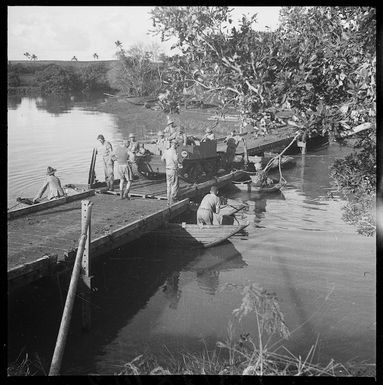 A tank crossing a pontoon bridge, with folding boats below, New Caledonia