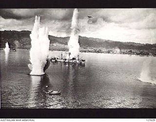 WEWAK, NEW GUINEA. 1944. ATTACK BY B25 BOMBER AIRCRAFT OF FIFTH AIR FORCE, UNITED STATES ARMY AIR FORCE ON JAPANESE SHIPPING IN THE HARBOUR. NOTE B25 AT MASTHEAD HEIGHT AT LEFT OF BOMB BURST IN ..