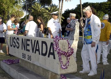 A Pearl Harbor survivor (foreground, right) pauses to reflect at the USS NEVADA Memorial at Pearl Harbor, Hawaii, on Dec. 8, 2006, during the joint Navy/National Park Service ceremonies commemorating the 65th Anniversary of the attack on Pearl Harbor. More than 1,500 Pearl Harbor survivors, their families and their friends from around the nation joined the more than 2,000 distiguished guests and the general public for the annual Pearl Harbor observance. (U.S. Navy photo by Mass Communication SPECIALIST 2nd Class Lindsay J. Switzer) (Released)