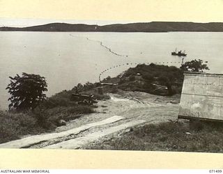PORT MORESBY, PAPUA, NEW GUINEA. 1944-03-27. NO. 1 GUN VIEWED FROM NO. 2 GUN EMPLACEMENT AT PAGA BATTERY, COAST ARTILLERY WITH THE ANTI-SUBMARINE BOOM IN THE BACKGROUND