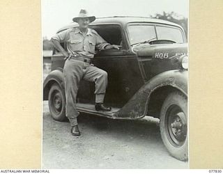 LAE BASE AREA, NEW GUINEA. 1944-12-27. SX25793 MAJOR N. LERAY-MYER, COMMANDING OFFICER, 8TH SALVAGE COMPANY BESIDE A CAPTURED JAPANESE STAFF CAR USED BY THE PERSONNEL OF THE UNIT AS A RUNABOUT