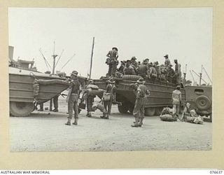 LAE, NEW GUINEA. 1944-11-02. PERSONNEL OF BATTALION HEADQUARTERS, 14/32ND INFANTRY BATTALION BOARDING AN AMPHIBIOUS LOAD CARRIER FOR THEIR TRIP OUT TO THE TROOPSHIP "CAPE ALEXANDER"