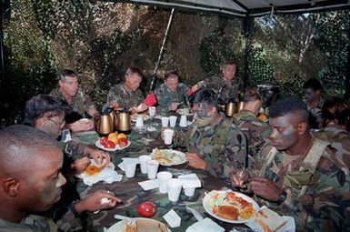 GEN Robert W. Riscassi, second from right, Vice CHIEF of STAFF, U.S. Army, and BGEN Craig Hagan, second from left, assistant Division Commander, 25th Infantry Division (Light) sit at the head table as they dine in the field with some of the division's troops