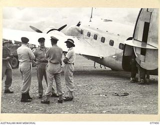 LAE AREA, NEW GUINEA. 1944-12-08. RAAF CREW MEMBERS OF GENERAL SIR THOMAS BLAMEY'S LOCKHEED "LODESTAR" AIRCRAFT AWAITING TRANSPORT TO THE CAMP. THEY ARE:- 406739 FLIGHT LIEUTENANT H.E. TEEDE, PILOT ..