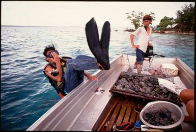 Workers from the Amoko shell farm in a boat, Manihiki, Cook Islands