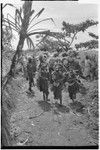 Bride price ritual: decorated men with spears charge in mock aggression, lead groom's group into the bride's village