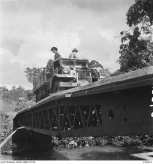 DONADABU, NEW GUINEA. 1943-11-03. VEHICLE PASSING OVER THE TEMPORARY BOX GIRDER BRIDGE AT EWARIGO CREEK WHERE TROOPS OF NO. 3 PLATOON, 18TH AUSTRALIAN FIELD PARK COMPANY, ROYAL AUSTRALIAN ENGINEERS ..
