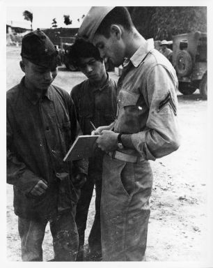 United States Marine Corps Reserves interpreter Cpl. Dunbar interrogating prisoners of war