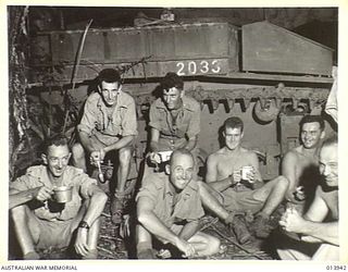 The Australian crew of an M3 Stuart tank having an early morning breakfast before going into action for the first time