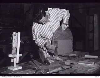 HOLLAND PARK, QLD. 1946-04-05. QX34431 LIEUTENANT R. N. MCDONALD OF TOOWOOMBA AT WORK IN THE CARPENTERS' SHOP, AS PART OF THE RELAXATION AND EXERCISE CARRIED OUT AT THE 102 AUSTRALIAN GENERAL ..