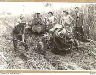 RAMU VALLEY, NEW GUINEA. 1943-11-26. A LIGHT 25 POUNDER GUN OF NO. 8 BATTERY 2/4 AUSTRALIAN FIELD REGIMENT BADLY BOGGED IN SWAMPY GROUND IN THE KESAWAI AREA. SHOWN ARE: QX5705 GUNNER BEGBIE; ..