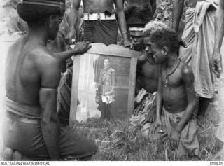 LAE, NEW GUINEA, 1946-02-14. AT A SPECIAL PARADE, MAJOR GENERAL B.M. MORRIS,GENERAL OFFICER COMMANDING AUSTRALIAN NEW GUINEA ADMINISTRATIVE UNIT, PRESENTED GIFTS (FRAMED COLOURED PHOTOGRAPHS OF ..