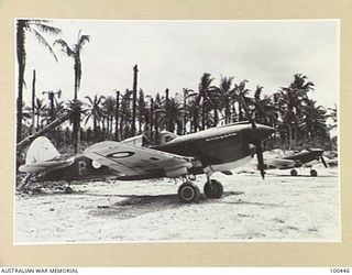 LOS NEGROS ISLAND, ADMIRALTY ISLANDS. KITTYHAWKS OF 77 SQUADRON RAAF ON MOMOTE STRIP A FEW DAYS AFTER THE INVASION OF THE ADMIRALTY ISLANDS. NOTE THE BOMB BLASTED TREES IN THE BACKGROUND