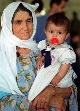 A Kurdish mother holds her daughter as they wait in line during processing at Andersen Air Force Base, Guam. Operation Pacific Haven provides airlift for some 2,700 refugees fleeing Iraq. The refugees will be housed at Andersen AFB, Guam, while they go through the immigration process for residence into the United States