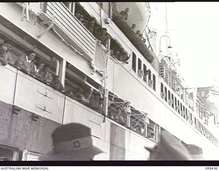 MILFORD HAVEN, NEW GUINEA, 1945-12-14. MEMBERS OF THE AUSTRALIAN ARMY NURSING SERVICE AND AUSTRALIAN ARMY MEDICAL WOMEN'S SERVICE LINE THE RAILS OF THE AUSTRALIAN TROOPSHIP SS MANUNDA, WAITING ..