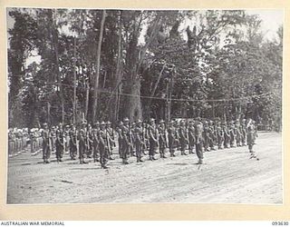 MOTUPENA POINT, BOUGAINVILLE, 1945-07-04. THE GUARD OF HONOUR FORMED BY D COMPANY HEADQUARTERS, 16 AND 20 PLATOONS, 2/1 GUARD REGIMENT, PRESENTS ARMS UPON THE ARRIVAL OF HIS ROYAL HIGHNESS, THE ..