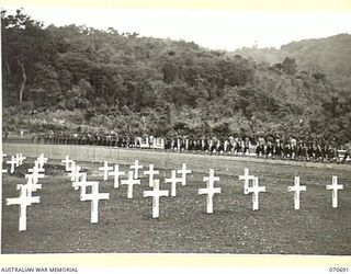 FINSCHHAFEN, NEW GUINEA, 1944-02-29. SERVICEMEN MARCH PAST THE GRAVES OF THE FALLEN AT THE CONCLUSION OF THE OFFICIAL OPENING OF THE FINSCHHAFEN WAR CEMETERY BY VX20308 MAJOR-GENERAL F.H. BERRYMAN, ..