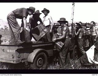 RAMU VALLEY, NEW GUINEA. 1943-10-07. TROOPS OF NO. 5 PLATOON, 2/2ND AUSTRALIAN SUPPLY DEPOT COMPANY, AUSTRALIAN ARMY SERVICE CORPS, 7TH AUSTRALIAN DIVISION, UNLOADING FRESH BUTTER AND MEAT AT THE ..