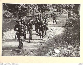 WONGINARA MISSION, NEW GUINEA. 1945-04-04. TIRED B COMPANY, 2/3 INFANTRY BATTALION TROOPS RETURNING FROM A PATROL, MUDDY, WEARY, AND SOAKED TO THE SKIN. (FOR IDENTIFICATION OF 10 NAMED PERSONNEL ..